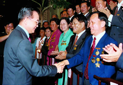 国务院总理温家宝2003年10月5日与全国劳动模范椰树集团董事长王光兴握手